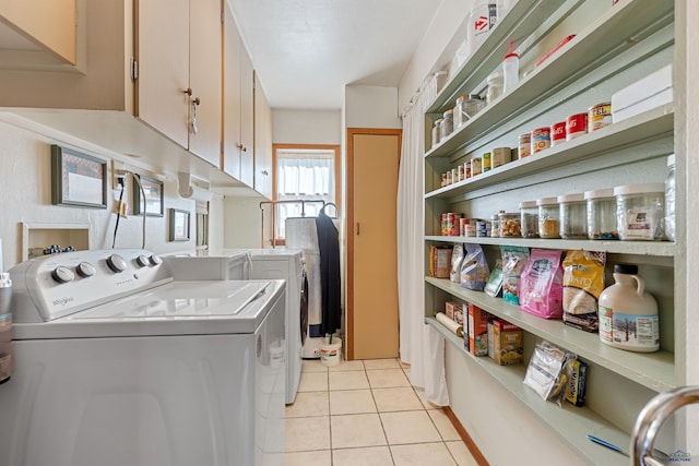 clothes washing area featuring laundry area, washer and clothes dryer, and light tile patterned floors