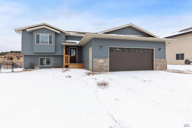 view of front of property with a garage, stone siding, and fence