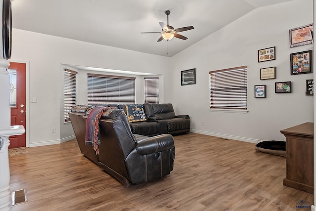 living room featuring a ceiling fan, visible vents, vaulted ceiling, and wood finished floors