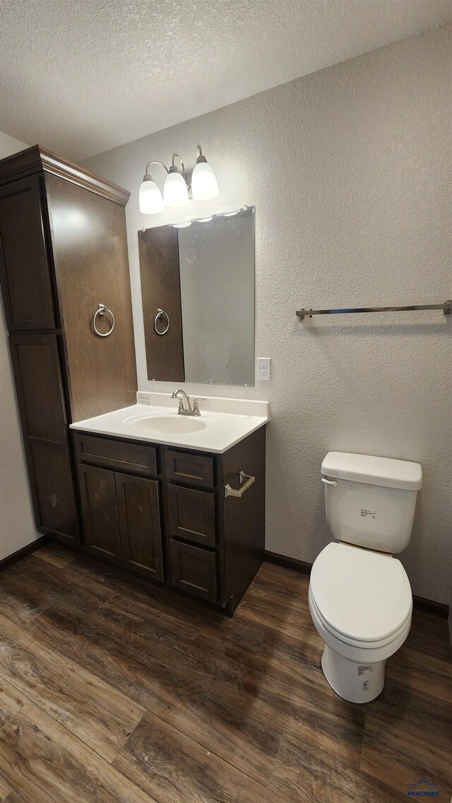424 Yelner Dr Lot 38Blk 4, Box Elder, SD 57719 - bathroom with wood finished floors, vanity, toilet, baseboards, and a textured ceiling