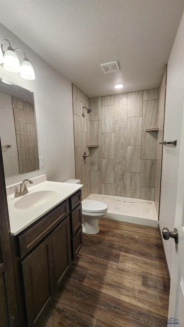 424 Yelner Dr Lot 38Blk 4, Box Elder, SD 57719 - full bath with toilet, tiled shower, a textured ceiling, vanity, and wood finished floors