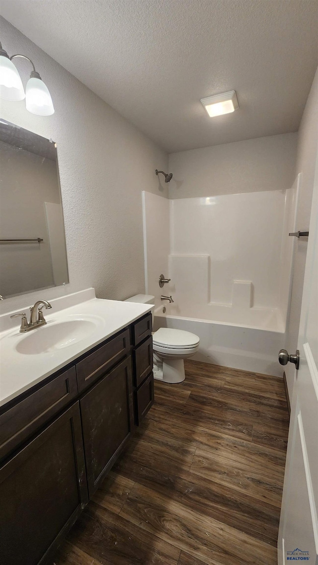 424 Yelner Dr Lot 38Blk 4, Box Elder, SD 57719 - bathroom with wood finished floors, toilet, shower / washtub combination, a textured ceiling, and vanity
