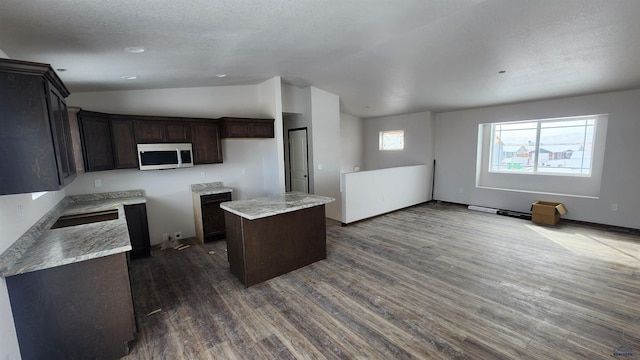 424 Yelner Dr Lot 38Blk 4, Box Elder, SD 57719 - kitchen featuring stainless steel microwave, dark wood-type flooring, lofted ceiling, a center island, and dark brown cabinets