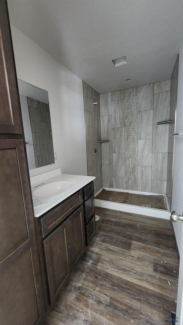 424 Yelner Dr Lot 38Blk 4, Box Elder, SD 57719 - bathroom featuring a walk in shower, vanity, a textured ceiling, and wood finished floors