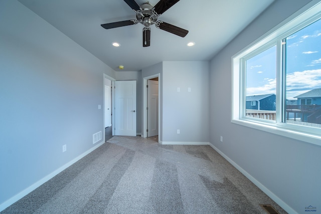 unfurnished bedroom featuring light carpet, visible vents, and baseboards