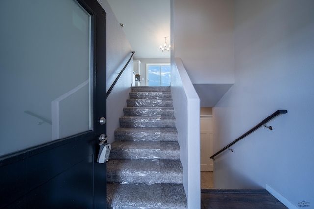 stairs with a notable chandelier