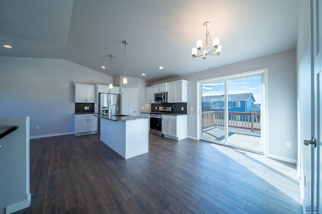 kitchen featuring dark countertops, appliances with stainless steel finishes, decorative backsplash, and dark wood-style flooring