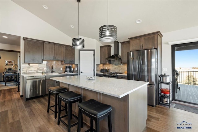 kitchen featuring wall chimney exhaust hood, dark brown cabinets, dark wood finished floors, and stainless steel appliances