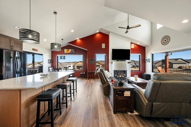 living area with a ceiling fan, recessed lighting, dark wood finished floors, and high vaulted ceiling