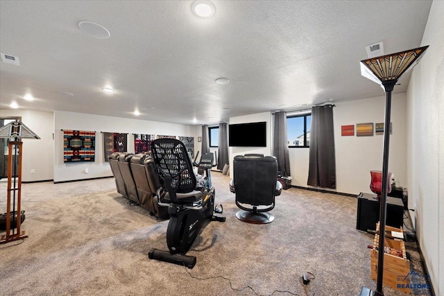 workout area featuring a textured ceiling, carpet flooring, visible vents, and baseboards