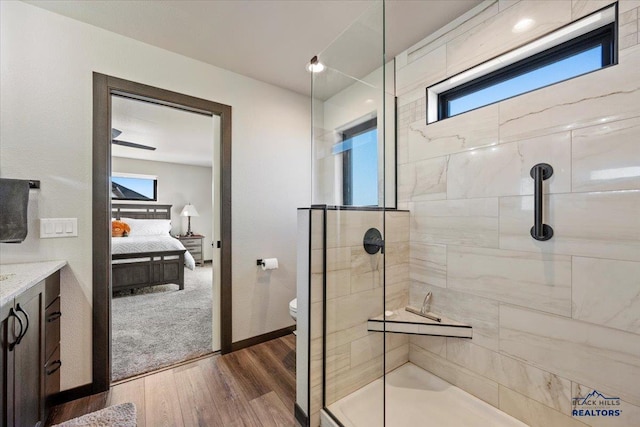 ensuite bathroom featuring a wealth of natural light, tiled shower, toilet, and ensuite bathroom