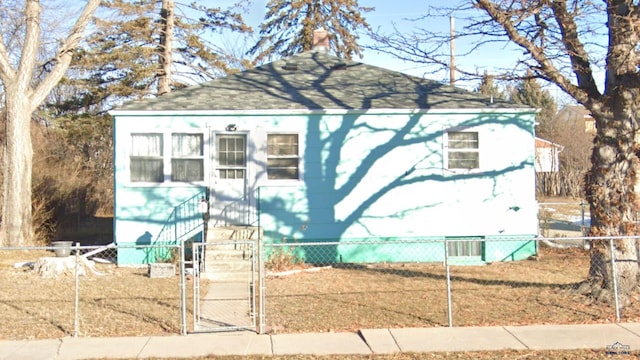 exterior space with a fenced front yard and a gate