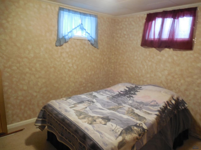 carpeted bedroom featuring wallpapered walls, multiple windows, baseboards, and ornamental molding