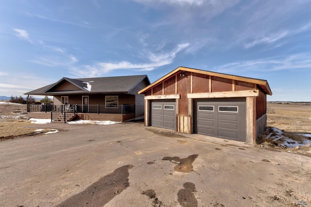 view of front of property with a porch, an outbuilding, and a detached garage