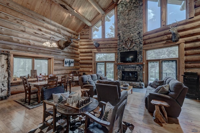 living area featuring beam ceiling, hardwood / wood-style floors, wooden ceiling, a fireplace, and a chandelier