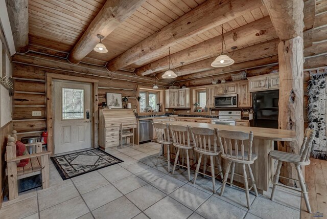 kitchen with a breakfast bar area, beam ceiling, a peninsula, stainless steel appliances, and wooden ceiling