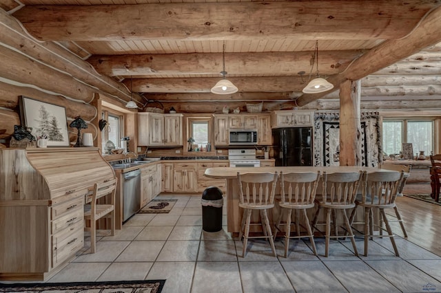 kitchen with a breakfast bar area, cream cabinetry, appliances with stainless steel finishes, wooden ceiling, and beamed ceiling