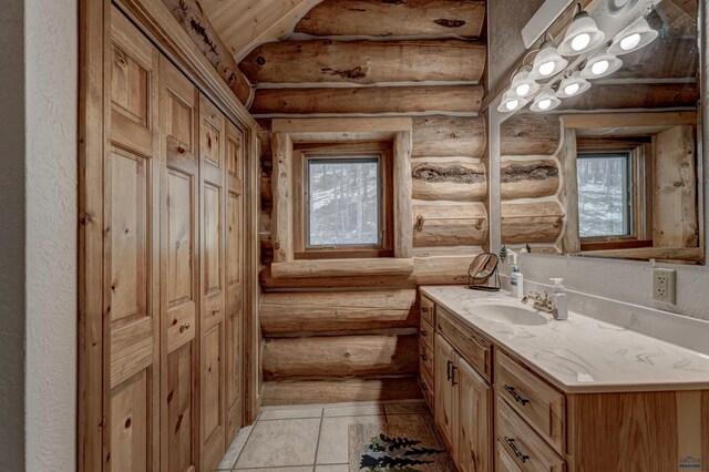 bathroom featuring vanity, lofted ceiling, a textured wall, and rustic walls