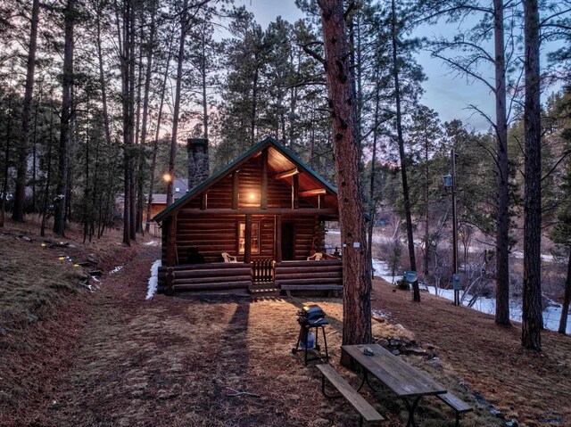 exterior space with log exterior and a chimney