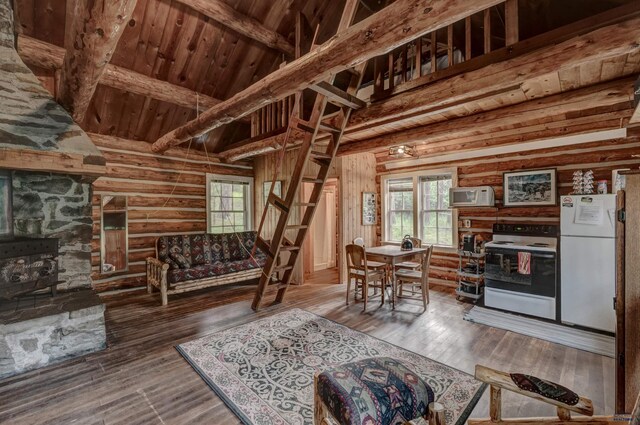 living room featuring beam ceiling, wooden ceiling, a wood stove, log walls, and wood-type flooring