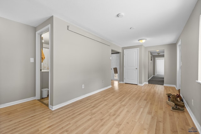 spare room with light wood-style flooring and baseboards