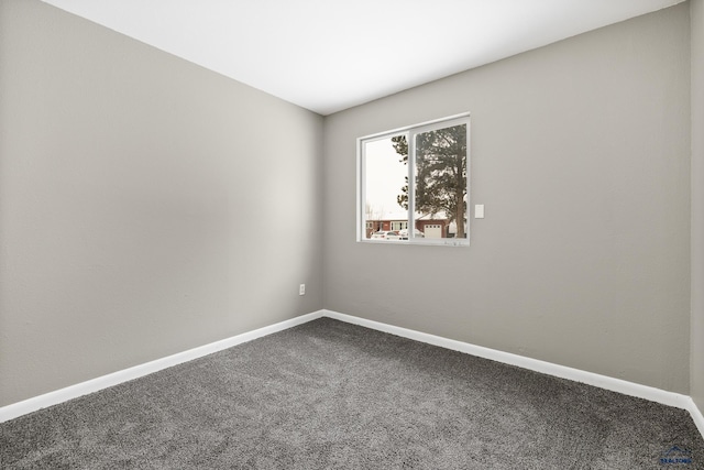 empty room with baseboards and carpet