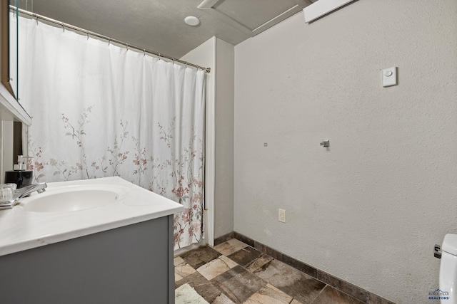 full bath featuring vanity and baseboards