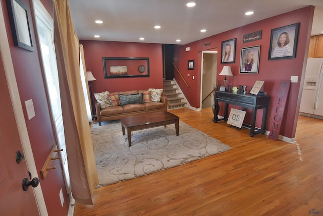 living room featuring recessed lighting, wood finished floors, and stairs