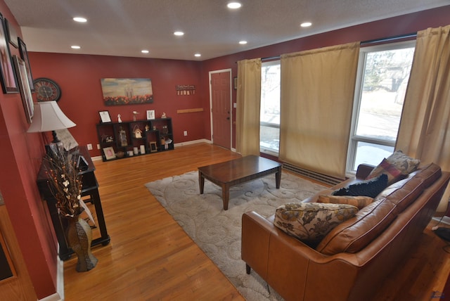 living room featuring recessed lighting, light wood-style flooring, and baseboards