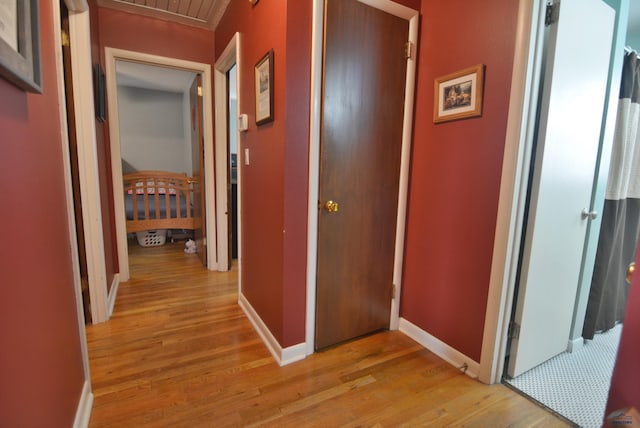 hall featuring baseboards and light wood-style floors