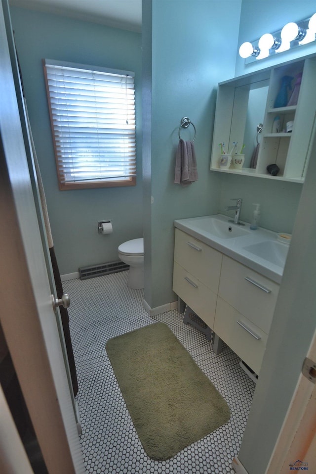 bathroom with visible vents, double vanity, a sink, tile patterned floors, and toilet