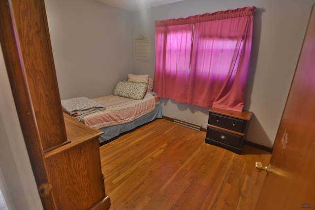 bedroom featuring visible vents, baseboards, and wood finished floors