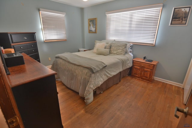 bedroom with light wood-type flooring and baseboards