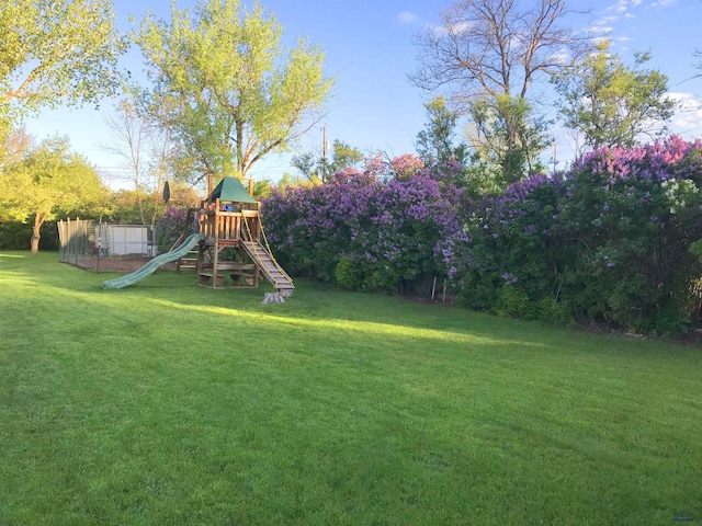 view of jungle gym with a yard and fence