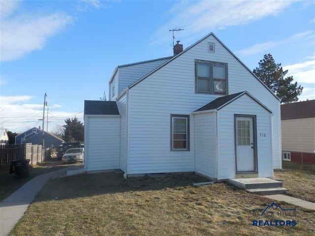 exterior space with a front yard and a chimney