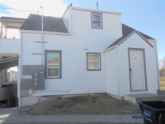 back of house featuring roof with shingles