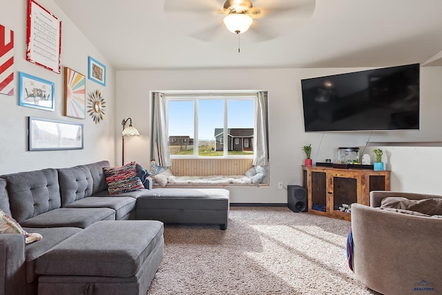 living area featuring baseboards, a ceiling fan, carpet flooring, and vaulted ceiling