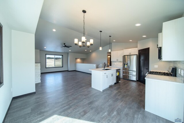 kitchen with tasteful backsplash, dishwasher, light countertops, stainless steel fridge, and a kitchen island with sink