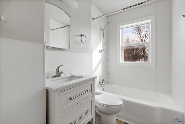 bathroom with vanity, toilet,  shower combination, and a textured wall