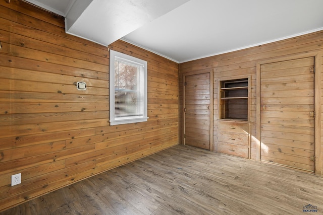 spare room with wooden walls and wood finished floors