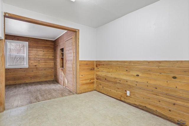 spare room with tile patterned floors and wood walls