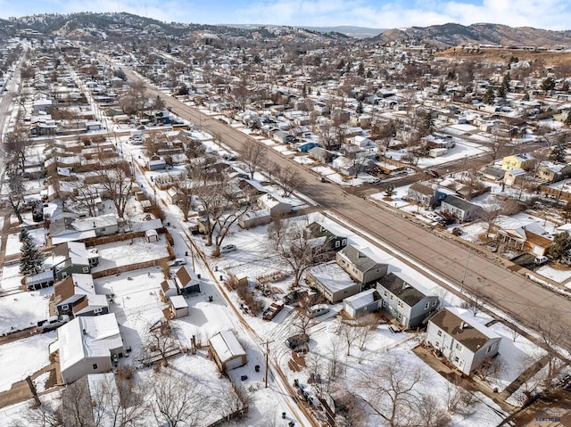 snowy aerial view with a mountain view and a residential view