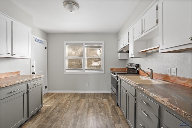 kitchen featuring dark wood-type flooring, under cabinet range hood, gray cabinets, electric stove, and a sink