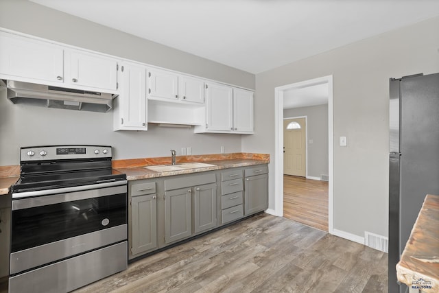 kitchen with visible vents, gray cabinets, a sink, under cabinet range hood, and appliances with stainless steel finishes