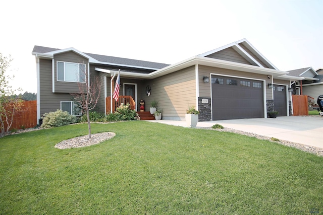 view of front facade featuring driveway, a front lawn, stone siding, fence, and an attached garage