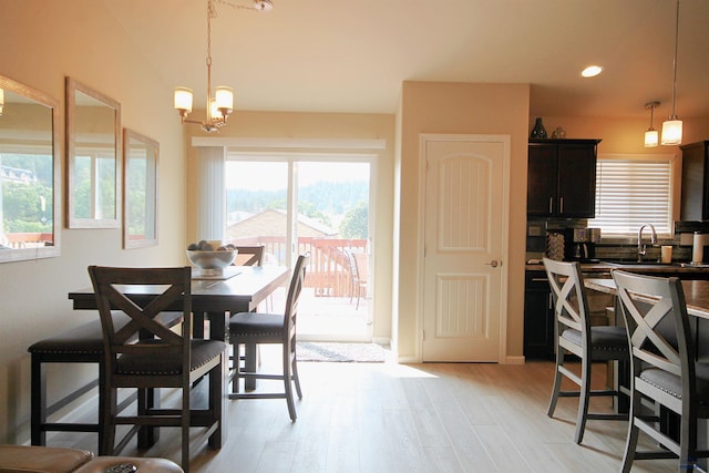 dining area with recessed lighting, a notable chandelier, and light wood-style flooring