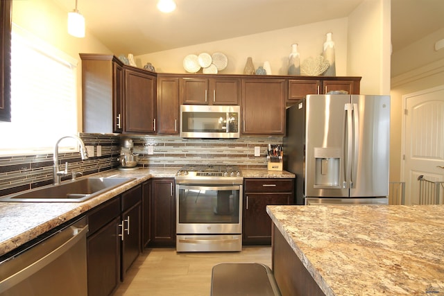 kitchen featuring a sink, lofted ceiling, tasteful backsplash, and appliances with stainless steel finishes