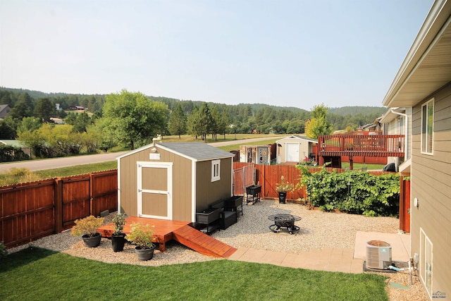 view of shed featuring a fenced backyard and an outdoor fire pit