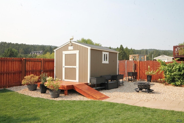 view of shed featuring a fire pit and a fenced backyard