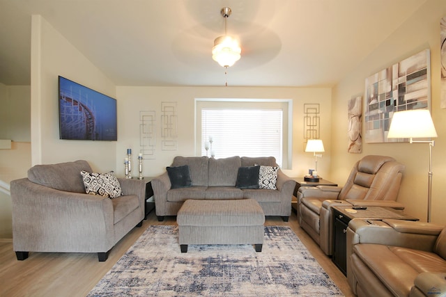 living area with light wood-style floors and vaulted ceiling